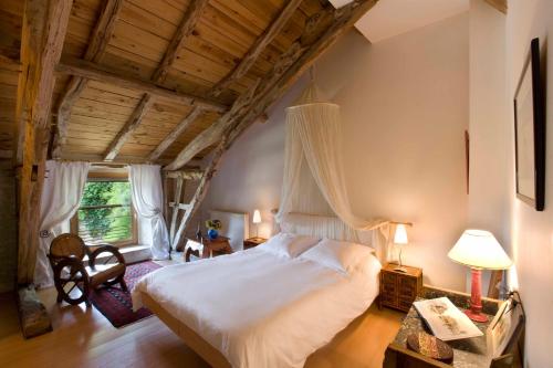 a bedroom with a large white bed in a room at La Vayssade - Grand Gîte de charme - 14 pers - Piscine & Jacuzzi in Lalbenque