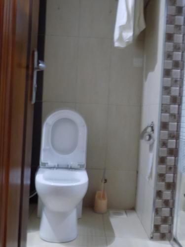 a bathroom with a toilet with the lid up at Freedom City Hotel Najjanankumbi Kamapala in Kampala