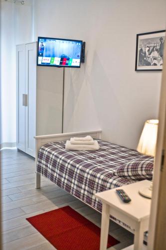 a room with a bed with a tv on the wall at Fellini in Rome