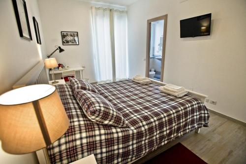 a small bedroom with a bed with a plaid blanket at Fellini in Rome