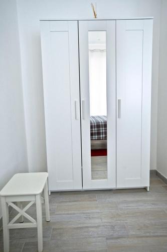 a white wardrobe in a room with a stool at Fellini in Rome