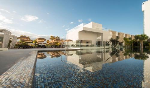 a swimming pool in front of a building at Hotel Alto Lido in Funchal