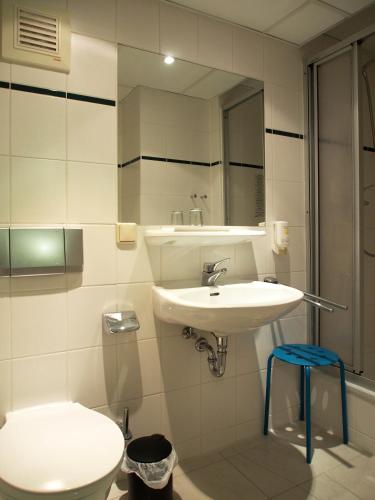a bathroom with a sink and a toilet and a mirror at Pension Ottendorf-Okrilla in Ottendorf-Okrilla