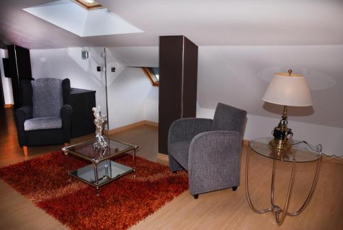 a living room with two chairs and a table at Hotel Villa de Cacabelos in Cacabelos