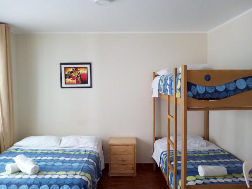 a bedroom with two bunk beds and a ladder at Paracas Backpackers House in Paracas