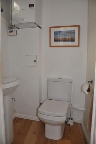 a white bathroom with a toilet and a sink at Little Sussex House in Rye