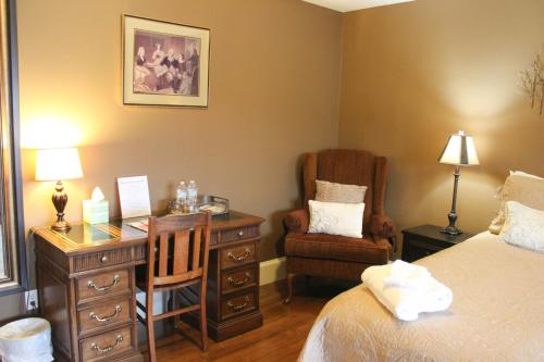 a bedroom with a desk and a bed and a chair at Leonard at Logan House in Grand Rapids