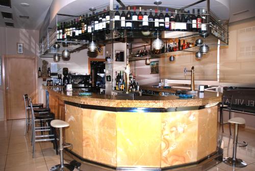 a bar in a restaurant with a counter and stools at Hotel Villa de Cacabelos in Cacabelos
