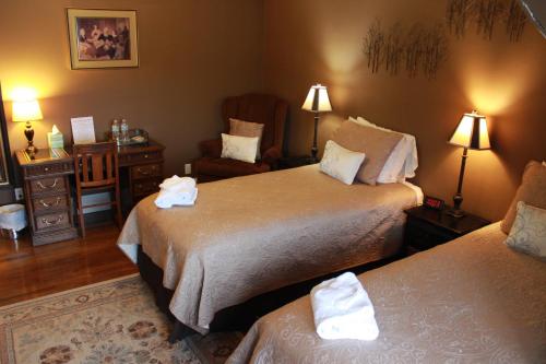 a hotel room with two beds and a chair at Leonard at Logan House in Grand Rapids