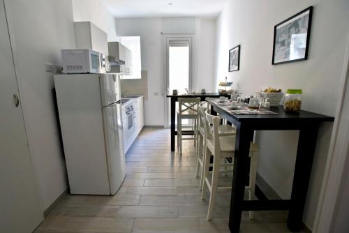 a kitchen with a white refrigerator and a table with chairs at Fellini in Rome