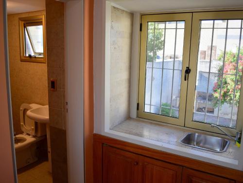 baño con lavabo y ventana en Vía Lavalle Suites 1 en San Luis