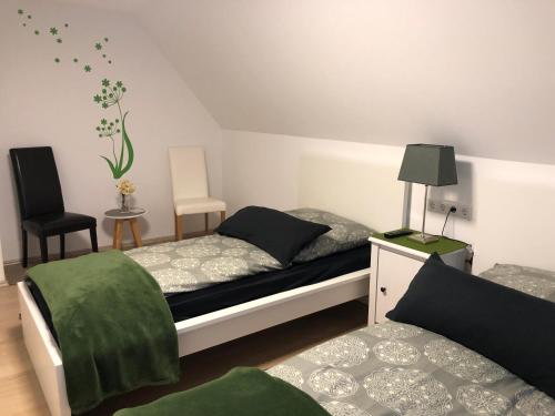 a bedroom with two beds and a chair at Messezimmer 4u in Düsseldorf