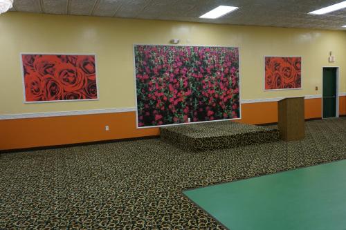 a room with three paintings of red flowers on the wall at Relax Inn in Vineland