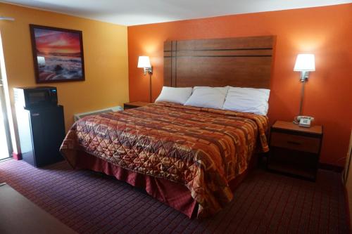 a hotel room with a large bed and two lamps at RELAX INN in Vineland