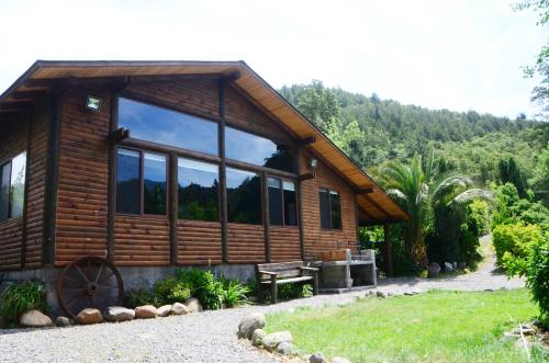 a log cabin with a large window on the side of it at Tumuñan Lodge in El Llano