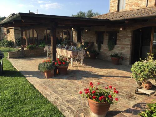 a patio with a table and chairs and flowers at La Villa degli Ulivi in Fermo