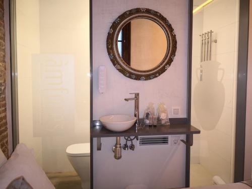 Un baño con un lavabo y un espejo en la pared. en Àmfores Boutique Guest House, en Barcelona