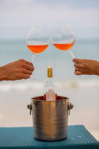 two people holding glasses of wine and a bottle at Solar Beach Hotel in Florianópolis