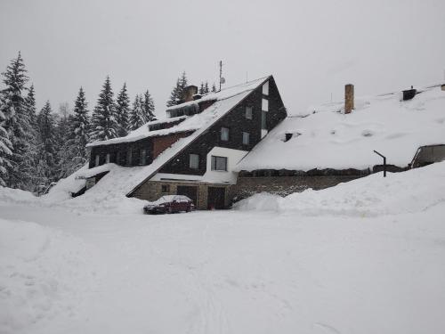 a snow covered house with a car parked in front of it at Na Losenici in Nicov