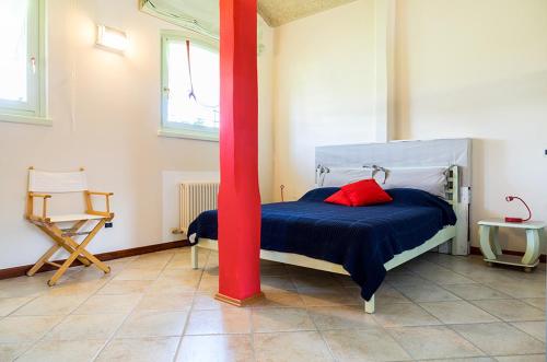 a bedroom with a bed with a red pole at Casa Petra in Vigasio
