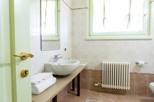 bagno con lavandino, specchio e radiatore di Casa Petra a Vigasio