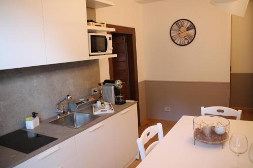 a kitchen with a sink and a clock on the wall at Residence Kalipè in Alagna Valsesia