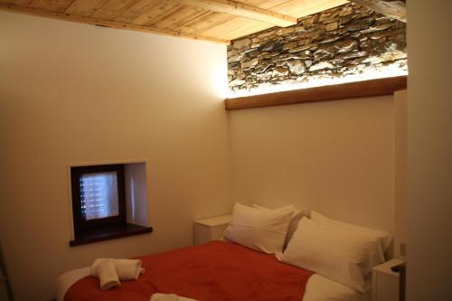 a bedroom with a bed and a stone wall at Residence Kalipè in Alagna Valsesia