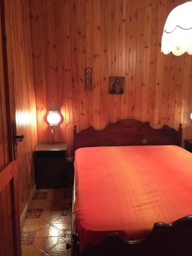 a bedroom with a red bed in a wooden wall at Casa Nilù in Rivisondoli