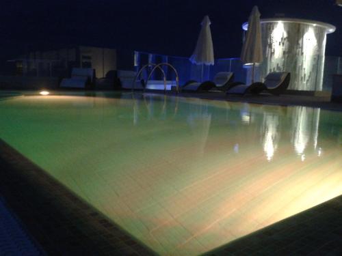 a swimming pool at night with a bowling alley at Hotel L'Approdo in Anzio