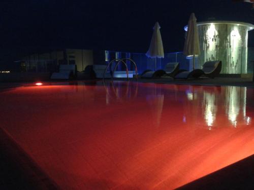 a dance floor with chairs and umbrellas at night at Hotel L'Approdo in Anzio