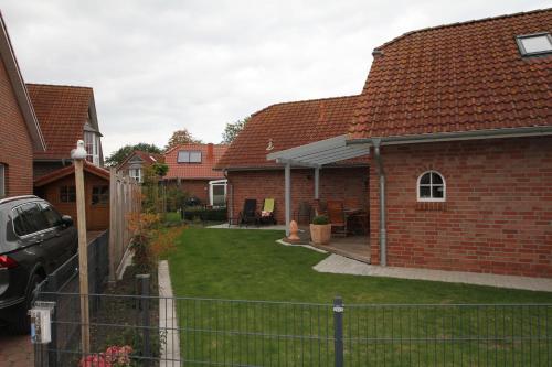 a house with a car parked in the yard at Skippersin5 in Greetsiel