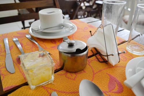 einen Tisch mit einem gelben Tischtuch und einer Teekanne in der Unterkunft Pousada Corais da Barra in Salvador