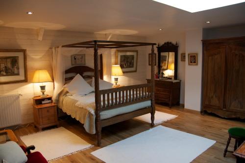 a bedroom with a canopy bed and two lamps at Relais Saint Aubin in Erquy