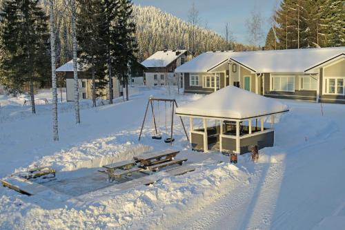 ein Haus mit Schnee auf dem Boden davor in der Unterkunft Apartments Huili in Tahkovuori