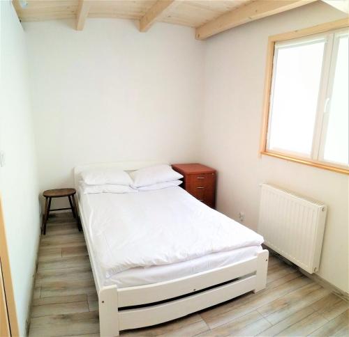 niewielka sypialnia z łóżkiem i oknem w obiekcie Domki Całoroczne - Tarlagowy Bór w mieście Bebło