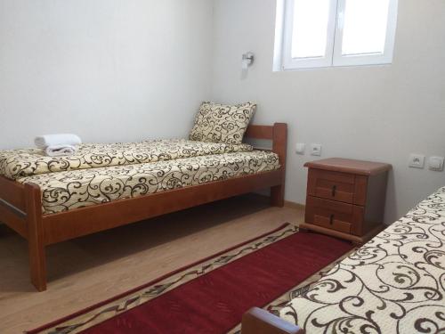 a small bedroom with a bed and a table at Domaćinstvo Krstajić - Rural holiday in Žabljak