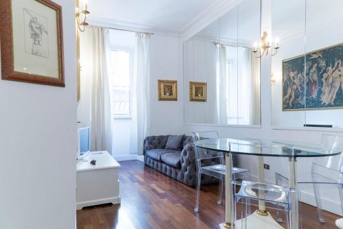 un soggiorno con tavolo in vetro e divano di Prinsi Apartments a Roma