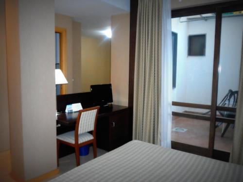 a hotel room with a desk and a bed and a chair at Hotel Diecimare in Cava deʼ Tirreni