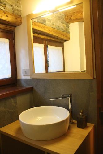 a white sink in a bathroom with a mirror at Residence Kalipè in Alagna Valsesia