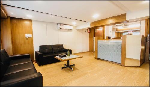 Qubestay Airport Capsule Hotel & Hostel في مومباي: غرفة معيشة مع أريكة وطاولة