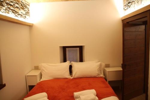 a bedroom with a bed with white pillows at Residence Kalipè in Alagna Valsesia