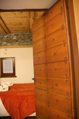 a bedroom with a bed and a wooden dresser at Residence Kalipè in Alagna Valsesia