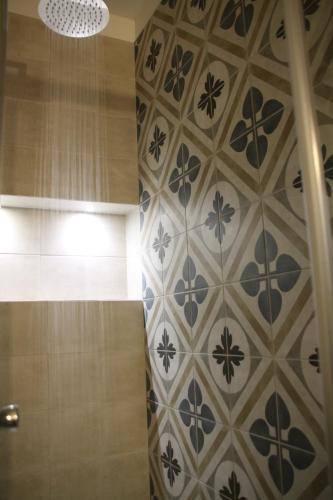 a bathroom with a tiled wall with blue and white tiles at Residence Kalipè in Alagna Valsesia