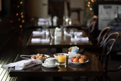a table with a breakfast of coffee and fruit on it at North Block Hotel in Yountville