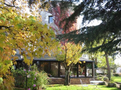 une maison avec une table et des chaises dans une cour dans l'établissement Le Relais de la Tour, à La Chaussée-Saint-Victor