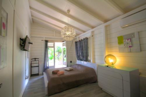 a bedroom with a bed and a chandelier at Villa avec piscine au Cap Est (MQFR35) in Le François