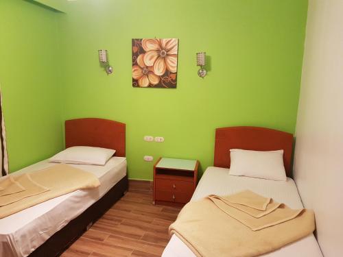 two beds in a room with green walls at Apartment in Porto Sokhna Pyramids for Families in Ain Sokhna