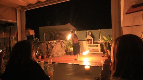 a woman is standing on a stage at night at Drago Hostel in Icod de los Vinos