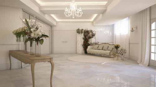 a living room with a couch and a table with flowers at Hotel Reyes Ziries in Albolote