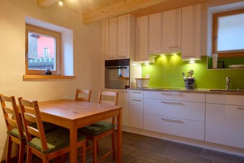 a kitchen with a wooden table and a green wall at El Stanzion in Roveredo